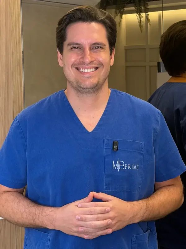 Dr. Manoel Hollanda sorrindo, vestindo pijama cirúrgico azul